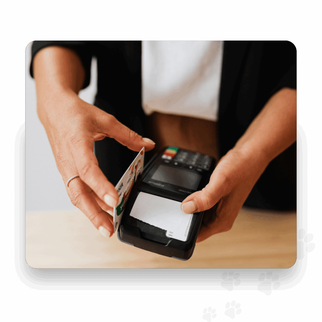 A person holds a payment terminal while tapping a credit card to make a contactless transaction—ideal for businesses using All-in-One Dog Boarding Software to streamline quick and secure payments.